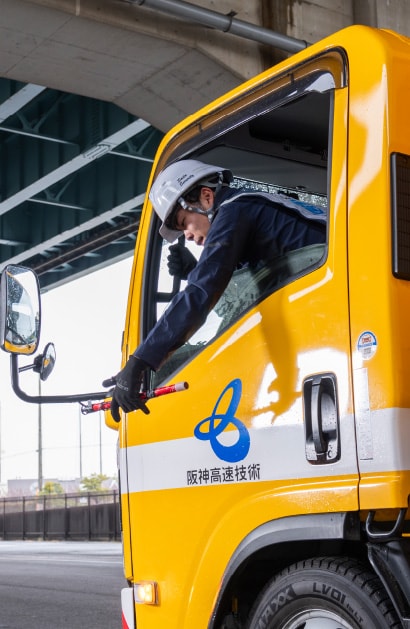 工事車両の助手席から合図を送る作業員